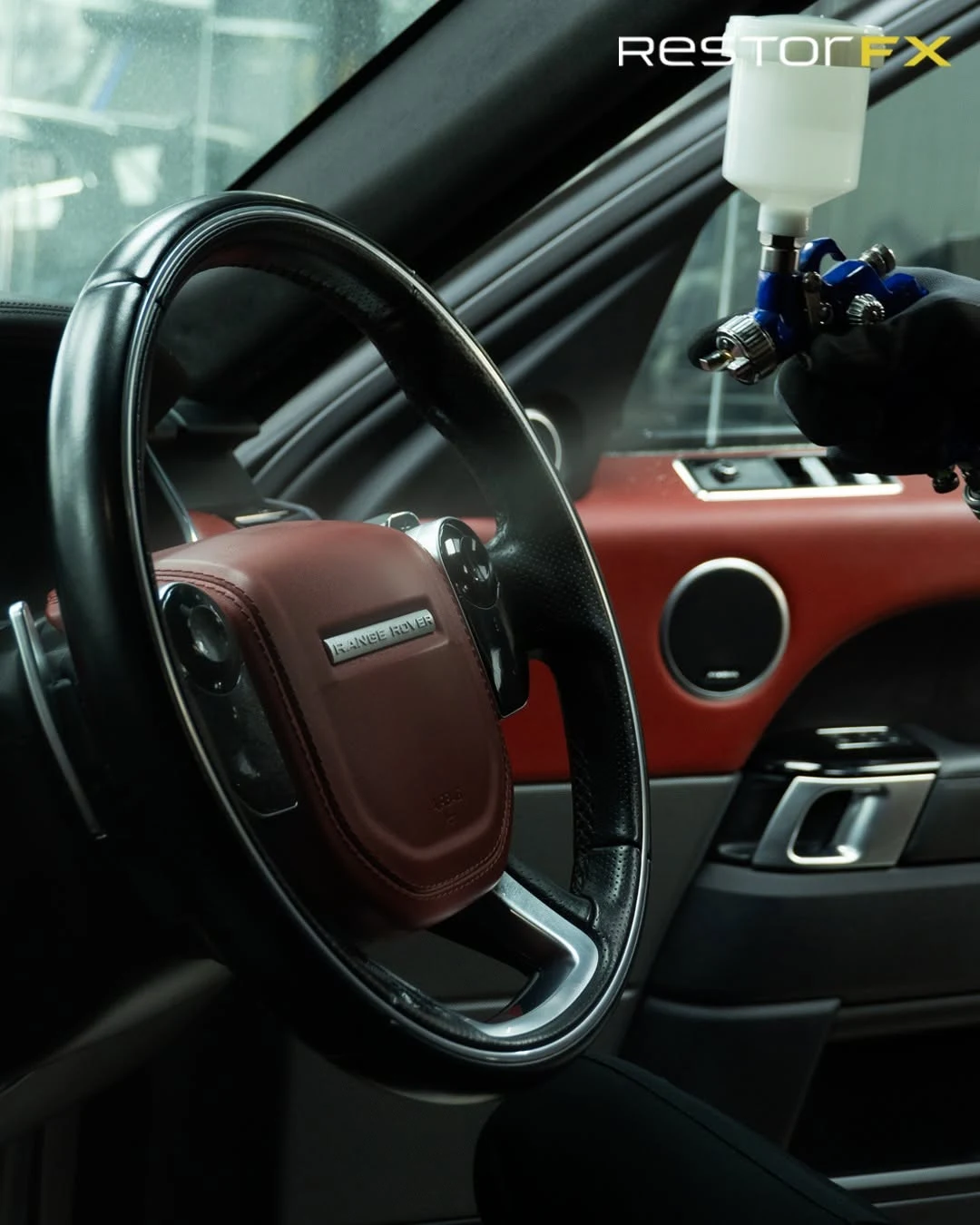 Technician applying precision coating and restoration to Range Rover leather steering wheel and cockpit